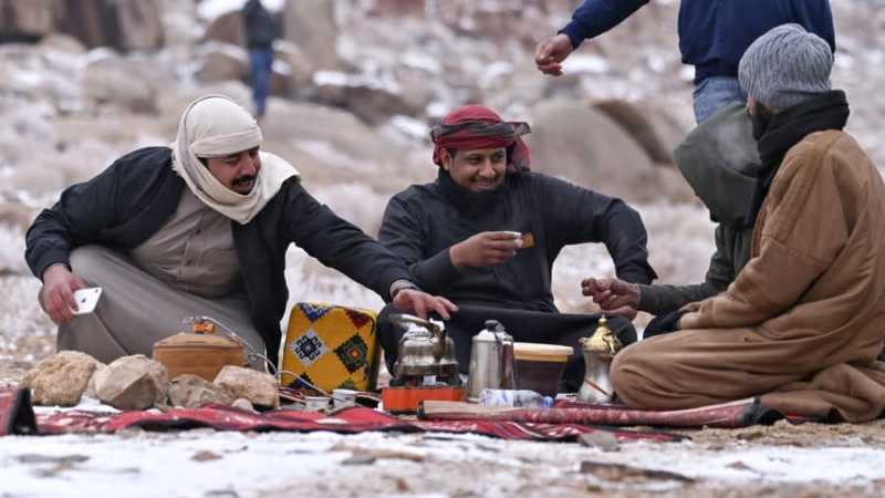 Warga Arab Saudi menikmati salju yang menyelimuti Gurun Badr