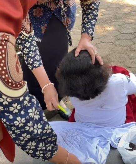 Guru viral membersihkan kutu di rambut muridnya