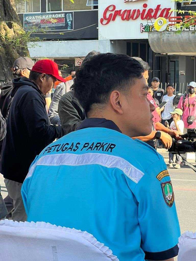     Wali Kota Solo Gibran Rakabuming Raka mengenakan baju bertuliskan Petugas Parkir saat Pawai Pembangunan