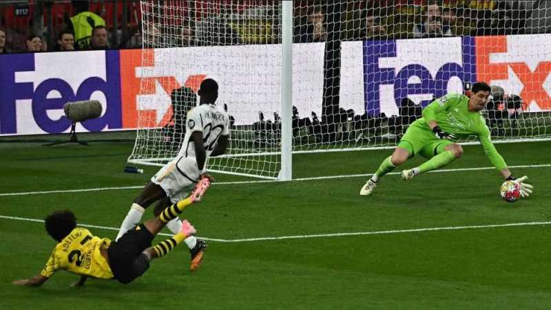     Borussia Dortmund vs Real Madrid 0-2: Thibaut Courtois menggagalkan serangan dari Karim Adeyemi (UEFA.com)